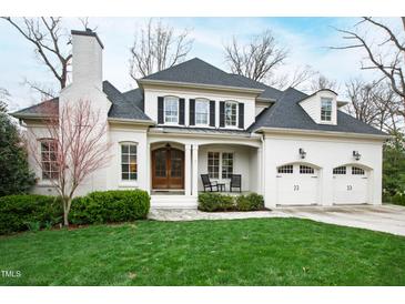 Elegant white brick home with a two-car garage and manicured lawn at 2635 Lakeview Dr, Raleigh, NC 27609