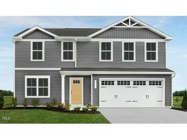 Charming two-story home features gray siding, attached garage and a well-manicured lawn at 359 Tormore Dr, Sanford, NC 27330