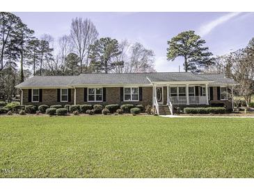 Charming brick home with a well-manicured lawn, mature trees, and inviting front porch at 45 Wimberly Ave, Rocky Mount, NC 27804