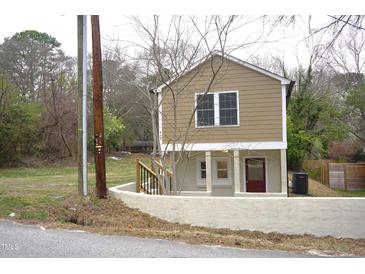Unique two-story home with tan siding and a charming red front door at 464 Longfellow St, Fuquay Varina, NC 27526