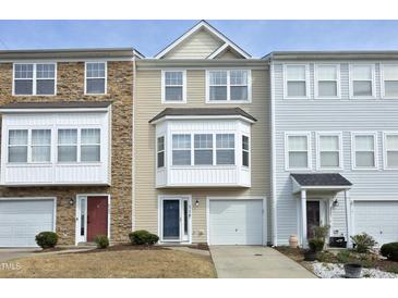Charming townhome featuring varied textures: stone, vinyl siding, and inviting curb appeal with small shrubbery at 4905 Briarstone Ct, Raleigh, NC 27610