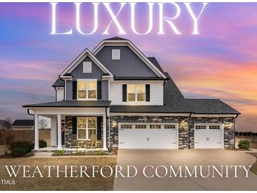 Stunning two-story home with three-car garage, stone accents, and inviting front porch at 59 N Clearbrook Ct, Angier, NC 27501