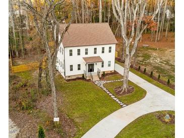 Charming two-story home featuring a lush green lawn, stone walkway, and a freshly paved driveway at 612 Lakeview Dr, Raleigh, NC 27603