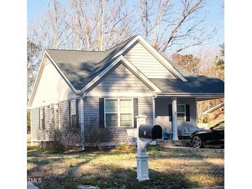 Charming home featuring gray siding, a cozy porch, and well-maintained landscaping at 8 Elaine Cir, Durham, NC 27703