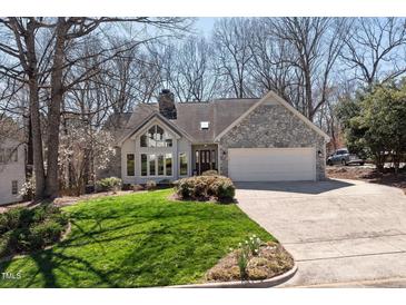 Charming home with stone accents, bright lawn, and an attached two car garage at 8116 Windsor Ridge Dr, Raleigh, NC 27615
