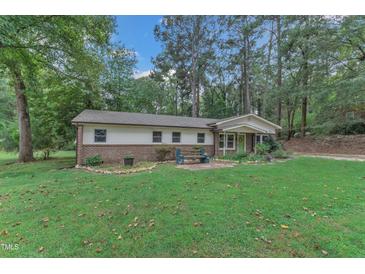 Charming single-story home with brick accents, a cozy front yard, and a welcoming green front door at 913 Ranch Farm Rd, Raleigh, NC 27603