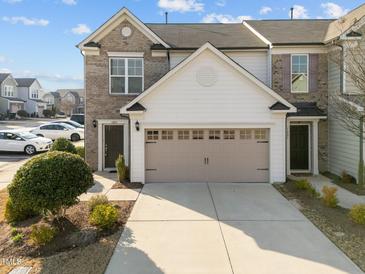 Charming townhome showcasing brick and siding with a two-car garage and well-maintained landscaping at 1003 Mirbeck Ln, Durham, NC 27713