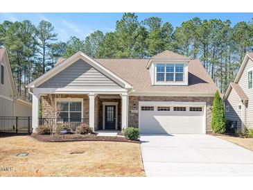 Charming home featuring stone and shingle siding, a covered porch, and an attached garage at 1013 Restoration Dr, Durham, NC 27703