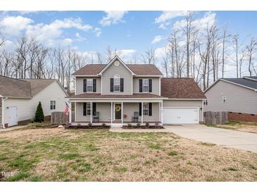 Charming two-story home with a welcoming front porch, beautiful landscaping, and an attached two-car garage at 1044 S Philwood Ct, Fuquay Varina, NC 27526