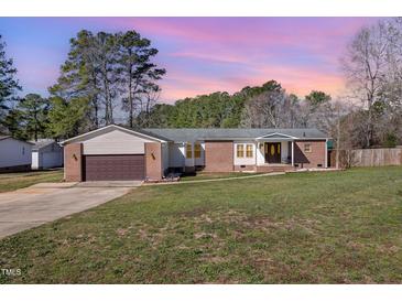 Charming single-story home with a brick facade, a brown garage door, and a well-manicured front lawn at 18 Five Ponds Dr, Sanford, NC 27332