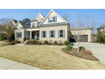 Charming brick home featuring a two-car garage, well-manicured lawn, and inviting curb appeal at 2046 Fellini Dr, Apex, NC 27502