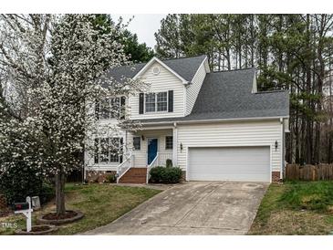 Charming two-story home with a well-manicured lawn, white siding, and a blossoming tree in the front yard at 2301 Lemuel Dr, Raleigh, NC 27615