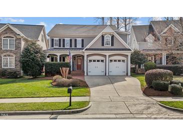 Charming two-story home with a two-car garage, landscaped yard, and covered porch at 233 Candia Ln, Cary, NC 27519