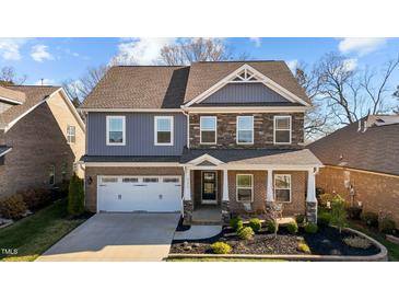 Charming two-story home with a covered front porch, brick and stone accents, and a well-manicured front yard at 234 Macallan Dr, Burlington, NC 27215