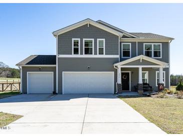 Charming two-story home features a two-car garage and a welcoming front porch with stylish columns at 2575 Sheriff Watson Rd, Sanford, NC 27332