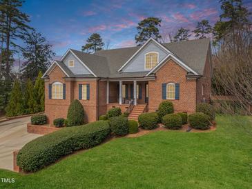 Charming brick home with a manicured lawn and inviting front porch, perfect for relaxation at 3204 Cobblestone Ct, Raleigh, NC 27607