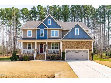 Charming two-story home with stone accents, covered porch, and attached two-car garage at 50 Lockamy Ln, Youngsville, NC 27596