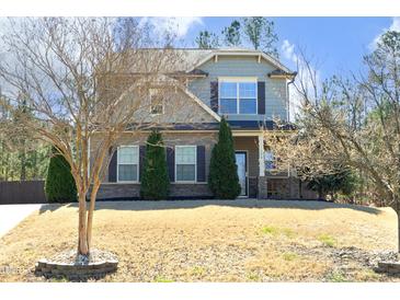 Charming two-story home with stone accents, manicured landscaping, and a welcoming front porch at 5204 Sapphire Springs Dr, Knightdale, NC 27545