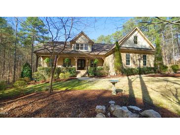 Charming stone and siding home with a covered front porch and landscaped yard surrounded by mature trees at 5640 Bella Terra Ct, Wake Forest, NC 27587