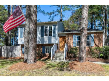 Charming two-story home with brick and siding, complemented by blue shutters and mature trees at 8612 Keegan Ct, Raleigh, NC 27613