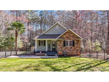 Charming single-Gathering home boasts a welcoming front porch, stone accents, and well-manicured lawn at 113 Pony Dr, Louisburg, NC 27549