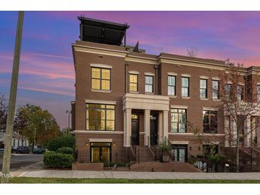 Beautiful brick townhome featuring a rooftop deck and professionally manicured landscaping at 117 S Bloodworth St, Raleigh, NC 27601