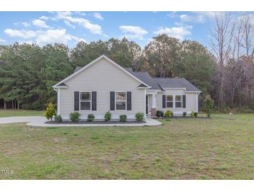 Charming single-story home featuring manicured landscaping, a well-maintained lawn, and a welcoming entrance at 11771 Raleigh Rd, Four Oaks, NC 27524
