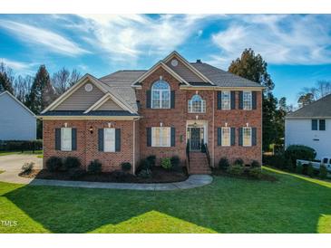 Two-story brick home featuring a manicured lawn, classic architectural details, and beautiful landscaping at 2720 Stratford Hall Dr, Raleigh, NC 27614