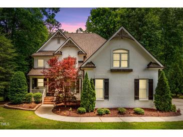 Charming two-story home featuring a lush landscaped yard, brick facade and inviting architectural details at 3421 Griffice Mill Rd, Raleigh, NC 27610