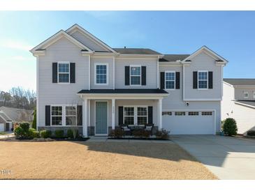 Charming two-story home with a well-manicured lawn, a two-car garage, and a welcoming front porch at 3508 Longleaf Estates Dr, Raleigh, NC 27616
