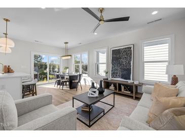 Bright and airy living room featuring modern decor, hardwood floors, and large windows at 517 Coleman St, Raleigh, NC 27610