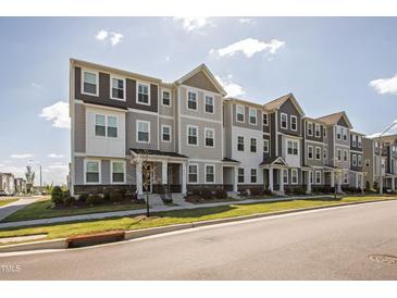 Modern townhome exteriors feature neutral colors, stone accents, and neat landscaping at 6434 Astor Elgin St, Raleigh, NC 27616