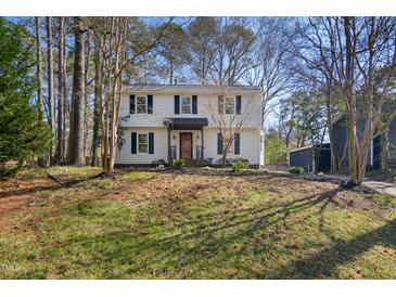 Traditional two-story home with white siding, dark shutters, and a well-maintained front lawn at 7216 Bluffside Ct, Raleigh, NC 27615