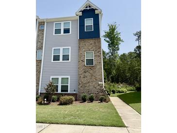 Two-story townhouse with a blend of brick and siding, complemented by a well-manicured lawn and sidewalk at 730 Firebrick Drive Dr, Cary, NC 27519