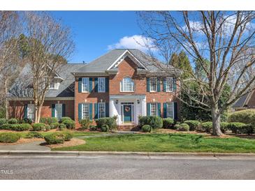 Charming brick two-story home featuring a well-manicured lawn and beautiful landscaping at 12504 Ribbongrass Ct, Raleigh, NC 27614