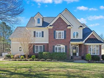 Beautiful brick home with light siding and a well-manicured lawn on a sunny day at 132 Mantle Dr, Clayton, NC 27527