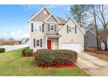 Charming two-story home features a red front door, well-maintained landscaping, and an attached garage at 153 N Farm Dr, Clayton, NC 27527