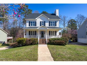 Charming two-story home with a welcoming front porch, classic black shutters, and landscaped front yard at 213 Yellow Poplar Ave, Wake Forest, NC 27587