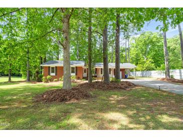 Charming single-story brick home with mature trees in front yard at 2968 Tram Rd, Fuquay Varina, NC 27526