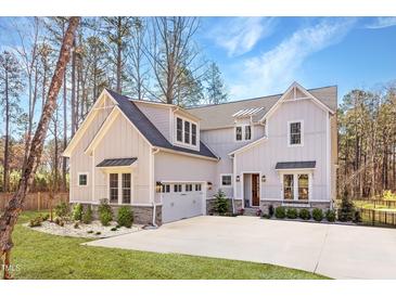 Inviting two-story home boasts a manicured lawn, light grey siding, and an attached two-car garage at 298 Bonterra Way, Chapel Hill, NC 27516