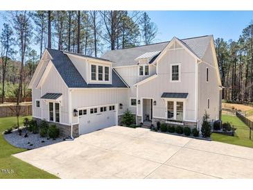 Stunning new construction featuring gray siding, stone accents, and a spacious three-car garage at 298 Bonterra Way, Chapel Hill, NC 27516