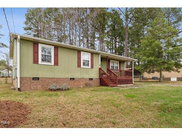 Charming single-story home featuring a covered front porch with red shutters and brick foundation at 402 Abbott Dr, Sanford, NC 27330