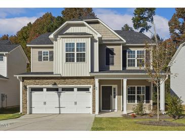 Charming two-story home with stone accents, a two-car garage, and a well-manicured lawn at 42 Chris Todd Way, Angier, NC 27501
