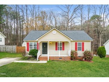 Charming single-story home featuring a cozy front porch, red shutters, and lush green lawn at 5717 Woof Pl, Knightdale, NC 27545