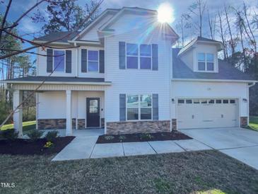 Charming two-story home with white siding, stone accents, and a well-maintained front yard at 69 Azul Dr, Clayton, NC 27520