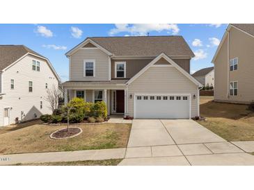 Charming two-story home boasts a well-maintained front yard and an attached two-car garage at 717 Tailrace Falls Ct, Wake Forest, NC 27587