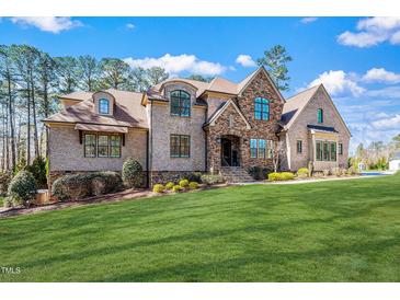 Stunning brick home boasts mature landscaping and architectural details under a clear sky at 1001 Welch Ln, Raleigh, NC 27614