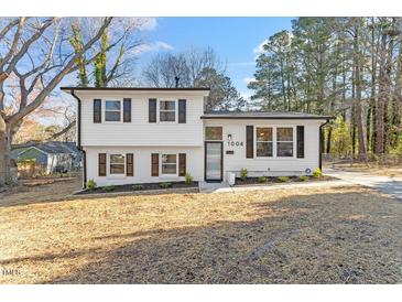 Charming two-story home featuring a white facade, contrasting shutters, and a well-maintained front yard at 1004 Helms Pl, Raleigh, NC 27610