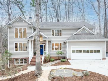 Charming two-story home featuring a well-manicured front yard, attached garage, and a classic blue front door at 104 Manchester Pl, Chapel Hill, NC 27516
