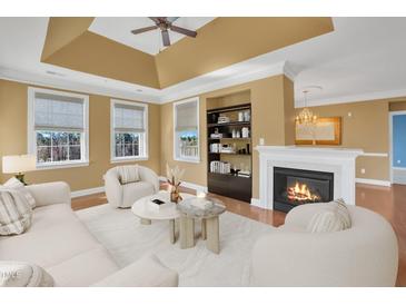 Comfortable living room with a cozy fireplace, built-in shelves, plush seating, and plenty of natural light from large windows at 10421 Rosegate Ct # 303, Raleigh, NC 27617